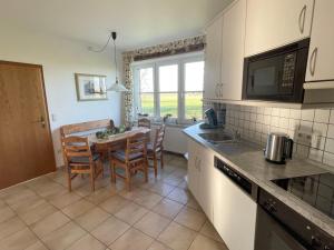 a kitchen with a table and chairs in a kitchen at Beimannskath in Kalkar