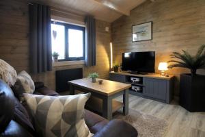 a living room with a couch and a table with a tv at Connemara luxury log out in Camus Eighter