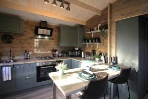 a kitchen with blue cabinets and a table with chairs at Connemara luxury log out in Camus Eighter