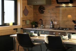 a kitchen with a table with chairs and a stove at Connemara luxury log out in Camus Eighter +12 photos