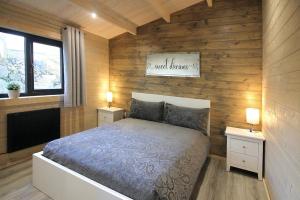 a bedroom with a bed and two night stands with lamps at Connemara luxury log out in Camus Eighter