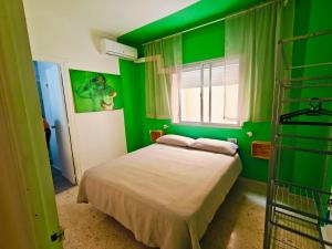 a green bedroom with a bed and a window at Maracuya House - Men Only in Torremolinos