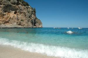 a group of people in the water at the beach at Hotel Ristorante La Conchiglia in Cala Gonone
