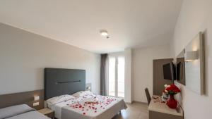 a bedroom with a bed and a table with flowers on it at HOTEL SETTIBI 20m dalla spiaggia in Giulianova