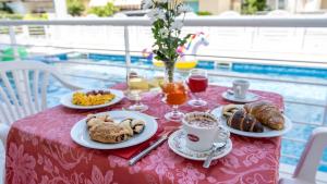 a table with a pink table cloth with breakfast food on it at HOTEL SETTIBI 20m dalla spiaggia in Giulianova +49 photos