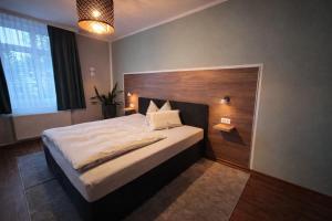a bedroom with a large bed with a wooden headboard at Hotel Am Vogelsang in Gevelsberg