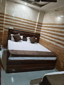 a bedroom with a large bed with a wooden headboard at Braj Darshan Bhawan in Jāmb