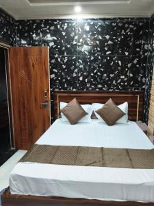 a bedroom with a white bed with a black wall at Braj Darshan Bhawan in Jāmb