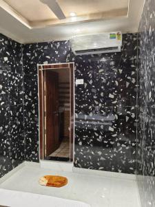 a bathroom with a black and white wall with a mirror at Braj Darshan Bhawan in Jāmb