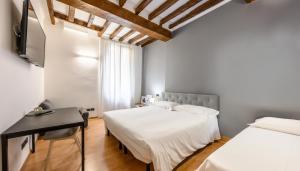 a bedroom with two beds and a desk at Emilia Studios 3 in Modena