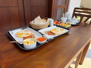 a tray of breakfast foods on a wooden table at Villa Paddy Heaven in Unawatuna
