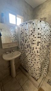 a bathroom with a sink and a white shower at Maximina Home in Comodoro Rivadavia