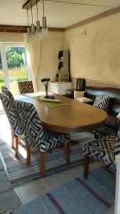 a living room with a wooden table and chairs at Metsanõmme puhkemaja ja saun in Lümati +24 photos