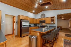 a kitchen with wooden cabinets and a stainless steel refrigerator at Cottage On The Cove by Railey Vacations in Swanton