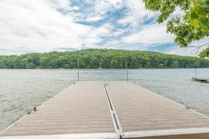 a dock on a lake with trees in the background at Corks Away by Railey Vacations in McHenry
