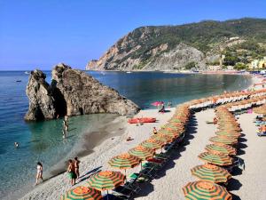 a beach with many umbrellas and people on the beach at Affittacamere Monterosso 5 Terre in Monterosso al Mare