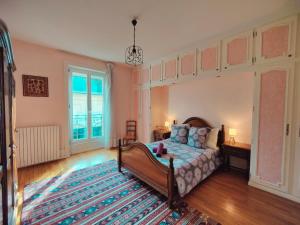 a bedroom with a bed and a large rug at Les Capucins - Élégance au Cœur de Remiremont in Remiremont