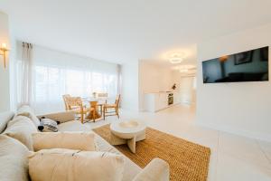 a white living room with a couch and a table at Green Island Inn in Fort Lauderdale