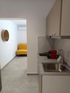 a kitchen with a sink and a yellow couch at Fox Studios in Paralia Sikias +25 photos