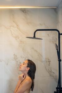 a woman in a shower under a shower head at Lagoon Villa Maldives in Thoddoo +44 photos