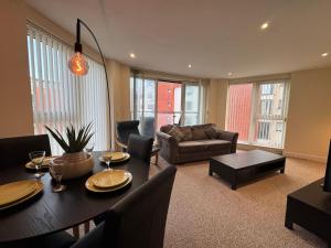 a living room with a table and a couch at Three bed apartment in the Tower in Swansea