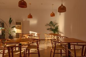 a restaurant with wooden tables and chairs and pendant lights at BOHOTEL Messonghi - Designer's Hotel in Mesongi