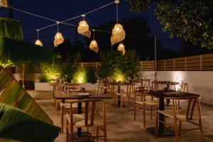 a patio with tables and chairs at night at BOHOTEL Messonghi - Designer's Hotel in Mesongi +104 photos