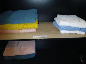 a shelf with different colored towels on it at Logement dans la campagne nérisienne in Néris-les-Bains