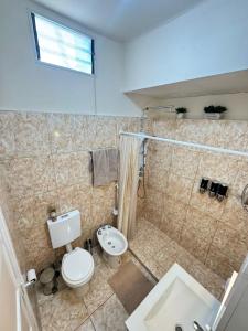 a bathroom with a toilet and a sink at Fortuna Apart in General Roca