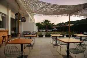 a patio with tables and chairs in a restaurant at BOHOTEL Messonghi - Designer's Hotel in Mesongi