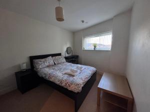 a small bedroom with a bed and a window at Three bed apartment in the Tower in Swansea