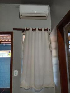 a curtain hanging in a room with a window at Pousada Costa Brasil Engenheiro Beltrao in Engenheiro Beltrão