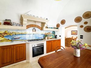 a kitchen with a sink and a stove and a table at La Torretta - Authentic Historic House with Panoramic Sea-View Terrace in Otranto Old Town - Marea Stays Collection in Otranto