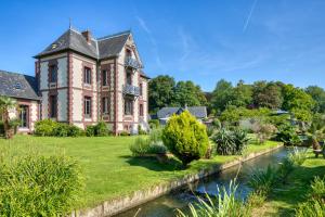 an old house with a river in front of it at Villa Argonne - Cottages & Spa Privatif in Ouville-la-Rivière