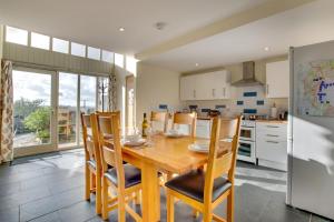 a kitchen with a wooden dining room table and chairs at 3 Bed in Totnes oc-bcdart in Broadhempston
