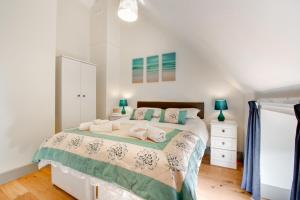 a bedroom with a bed with a green and white comforter at 3 Bed in Totnes oc-bcdart in Broadhempston