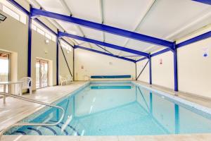 a large indoor swimming pool with blue beams at 3 Bed in Totnes oc-bcdart in Broadhempston