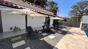 a patio with chairs and umbrellas next to a house at Villa Serena Sopetran in Sopetrán