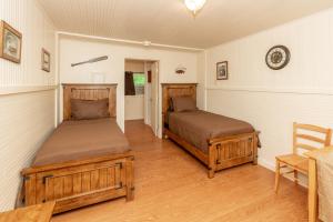 a bedroom with two beds and a table and a chair at Sun Outdoors Association Island in Henderson Harbor +42 photos