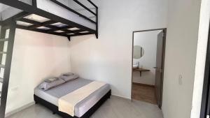 a white bedroom with a bed and a mirror at Villa Serena Sopetran in Sopetrán +10 photos