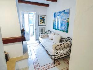 a living room with a couch and a painting on the wall at La Torretta - Authentic Historic House with Panoramic Sea-View Terrace in Otranto Old Town - Marea Stays Collection in Otranto