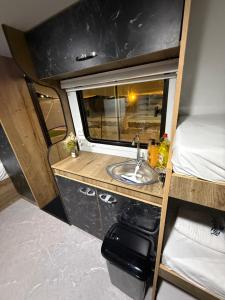 ein Badezimmer mit Waschbecken und ein Bett in einem Wohnmobil in der Unterkunft GoGolan in Madschdal Schams