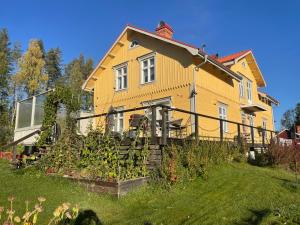 a yellow house with a garden in front of it at Granbo station in Granbo
