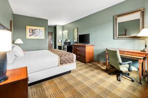 a hotel room with a bed and a desk and a computer at Americas Best Value Inn Somerville Texas in Somerville
