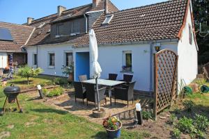 ein Haus mit einem Tisch und einem Sonnenschirm im Hof in der Unterkunft Ferienwohnung Bömitz in Bömitz