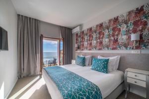 a bedroom with a bed with a view of the ocean at Castelo Guest House in Carvoeiro
