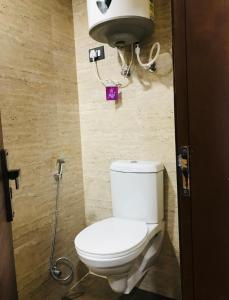 a bathroom with a white toilet in a stall at SkyNest in Dehradun +16 photos