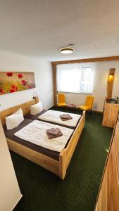 a hotel room with two beds and two chairs at Landhotel Sperlingsberg in Crimmitschau