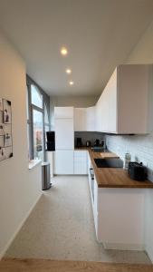 a kitchen with white cabinets and a large window at Chez Pomme in Brussels