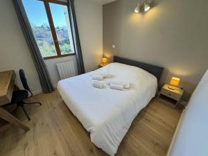 a bedroom with a white bed with towels on it at Appartement hyper centre Amiens in Amiens